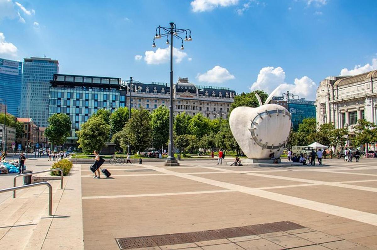 egy városi tér sétáló emberekkel és egy szoborral