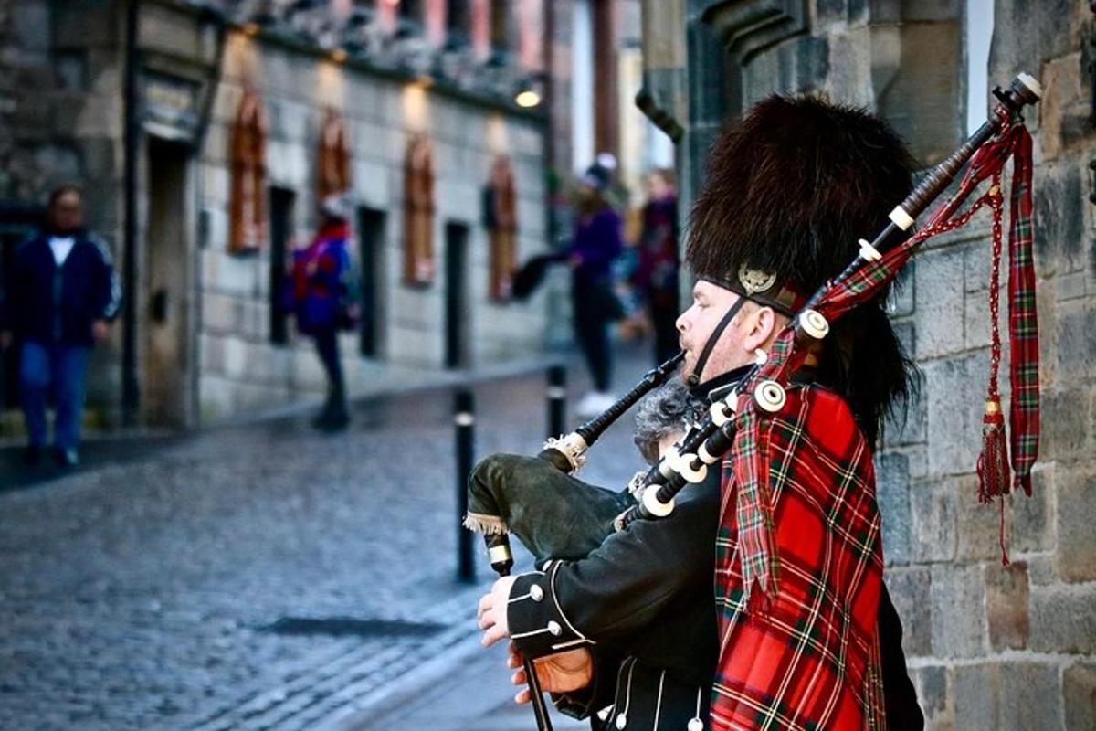 a man in a kilt playing a instrument on a street
