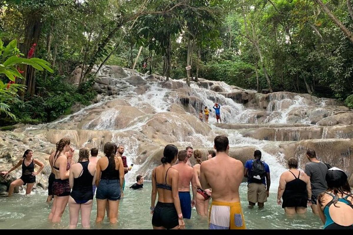група људи стоји у води близу водопада