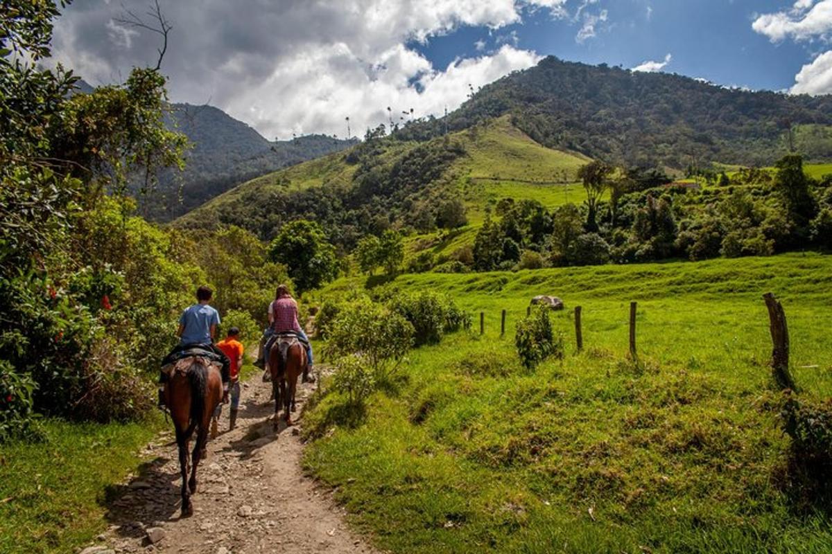 dues persones muntant a cavall per un camí de terra