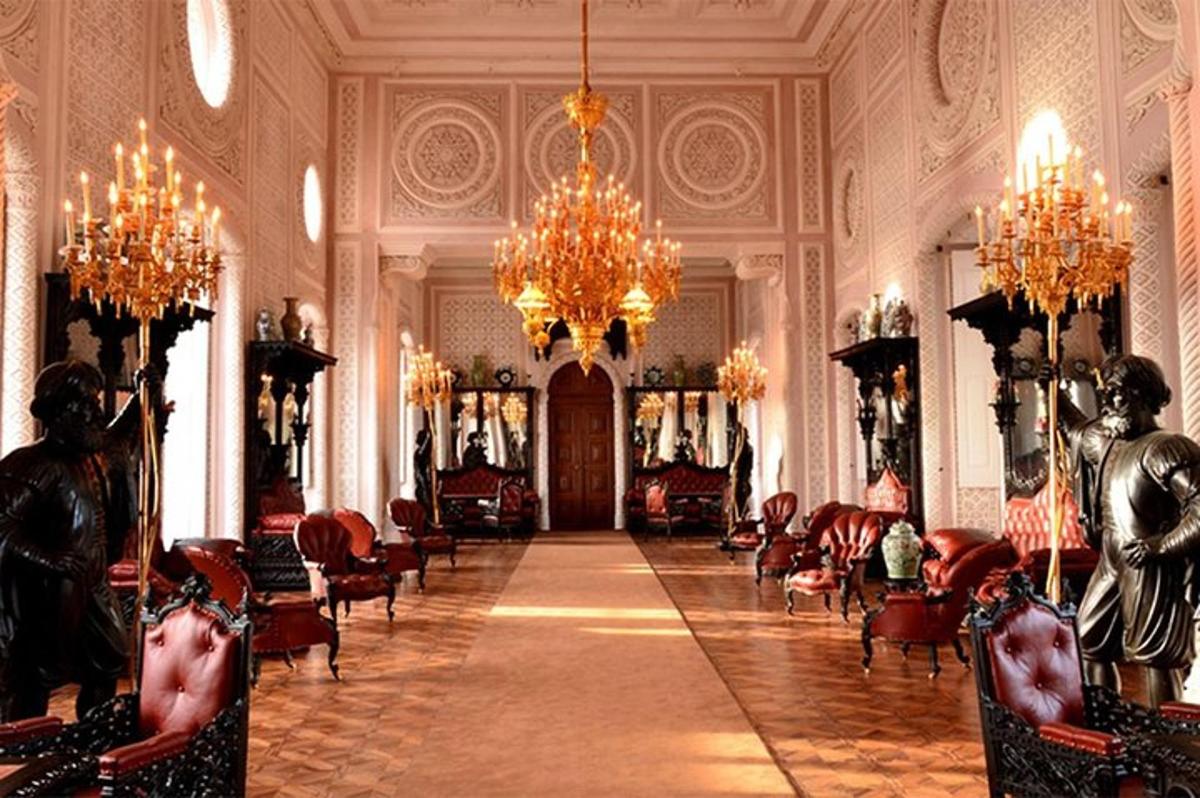 a large room with chandeliers and chairs in a building
