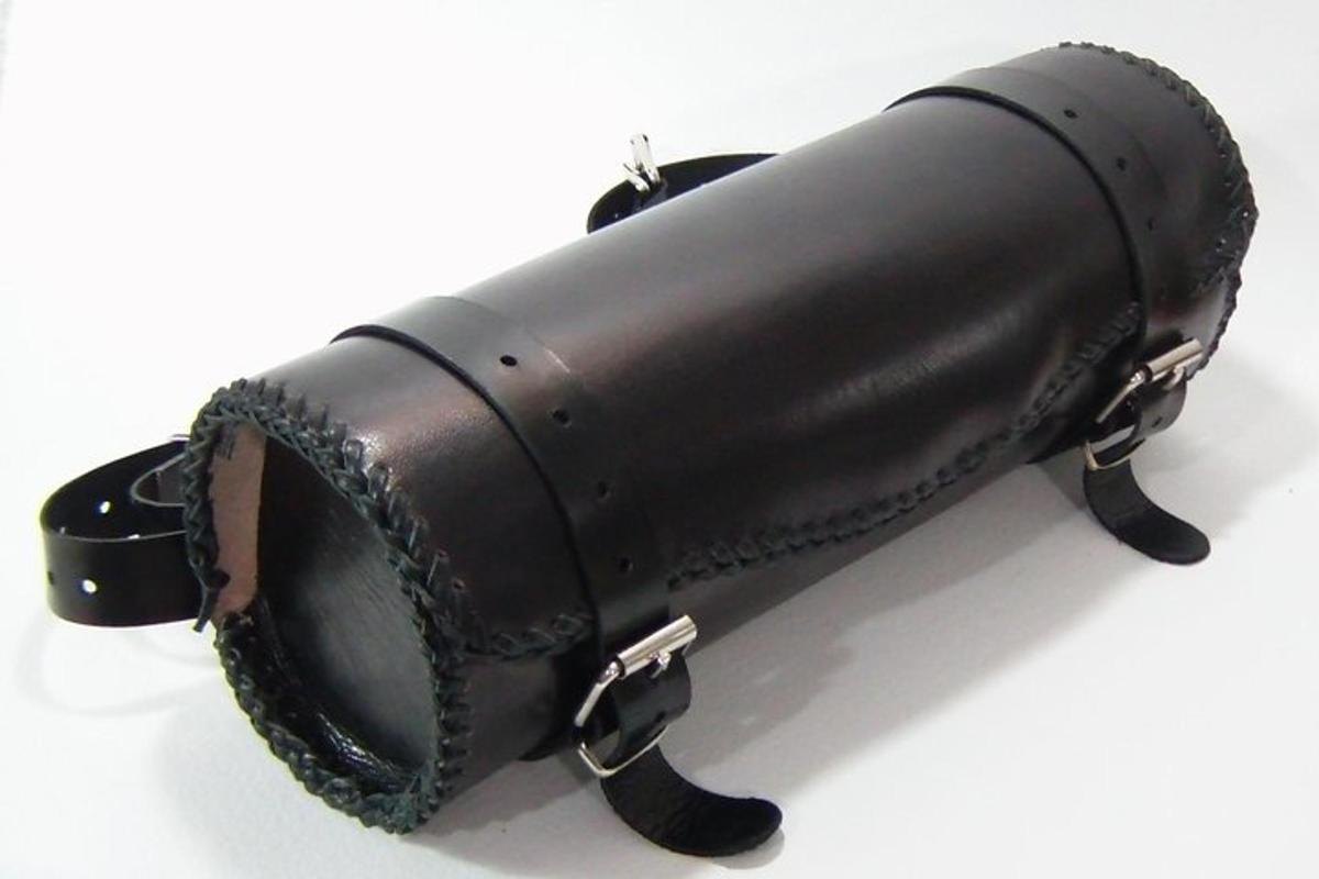 un primo piano di un cilindro di pelle nera con catene