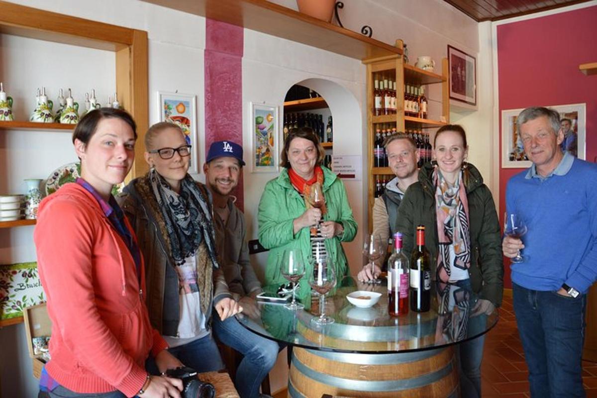 um grupo de pessoas em pé ao redor de uma mesa com garrafas de vinho