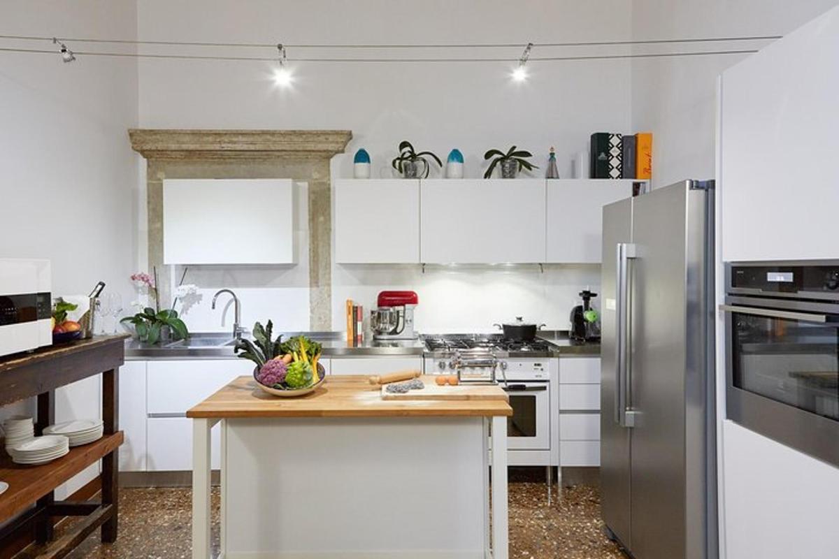 dapur dengan lemari putih dan meja kayu