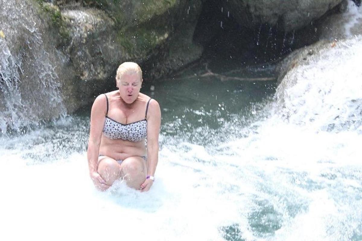 una dona asseguda a l'aigua d'un riu