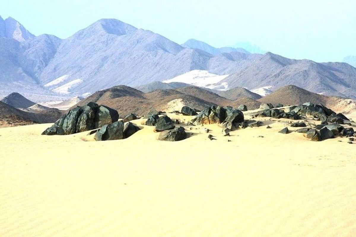 um deserto com rochas e montanhas ao fundo