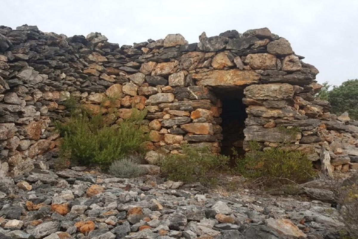an old stone building on top of a pile of rocks