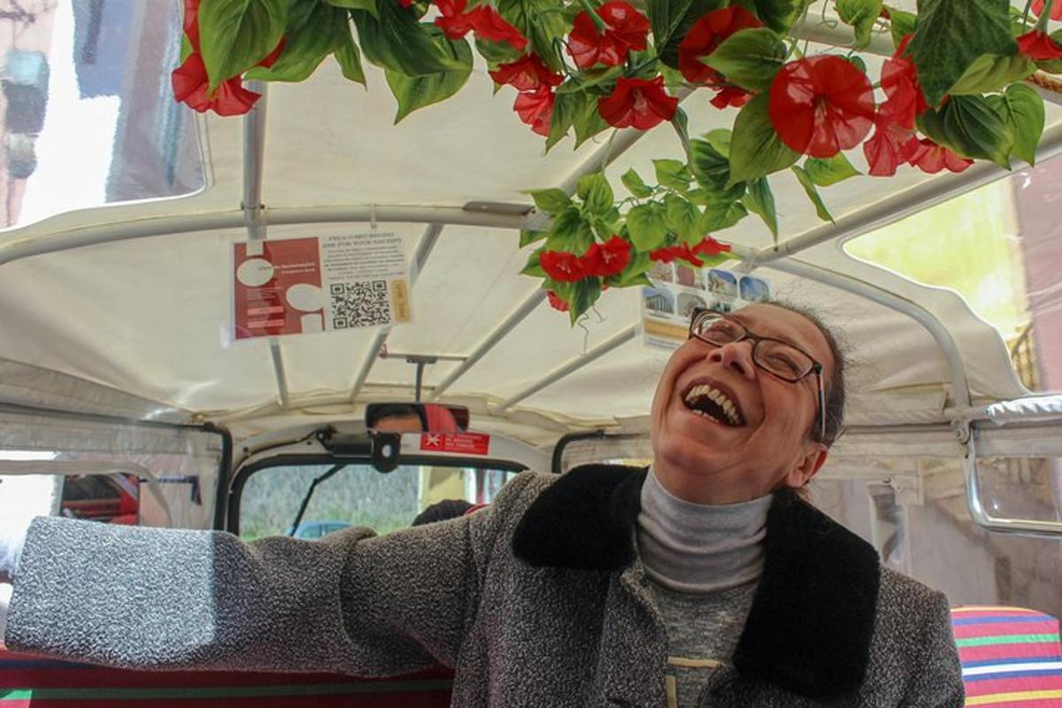 Un hombre se ríe mientras está sentado en una camioneta con flores.