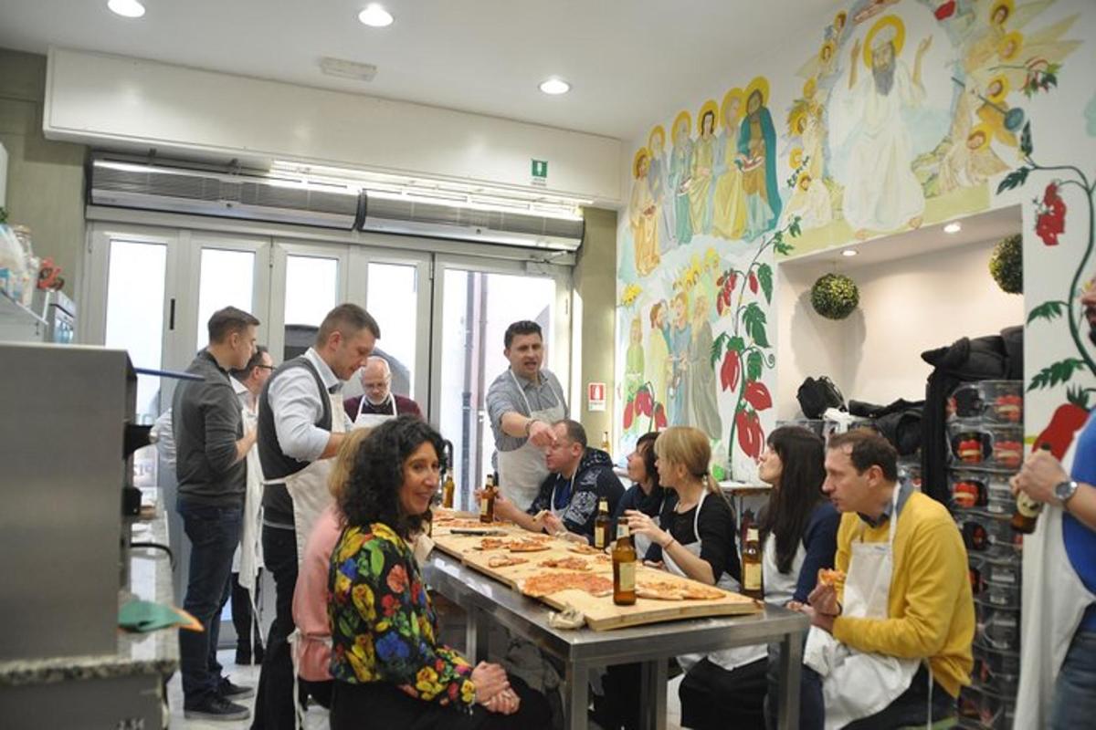 un gruppo di persone in piedi attorno a un tavolo con la pizza