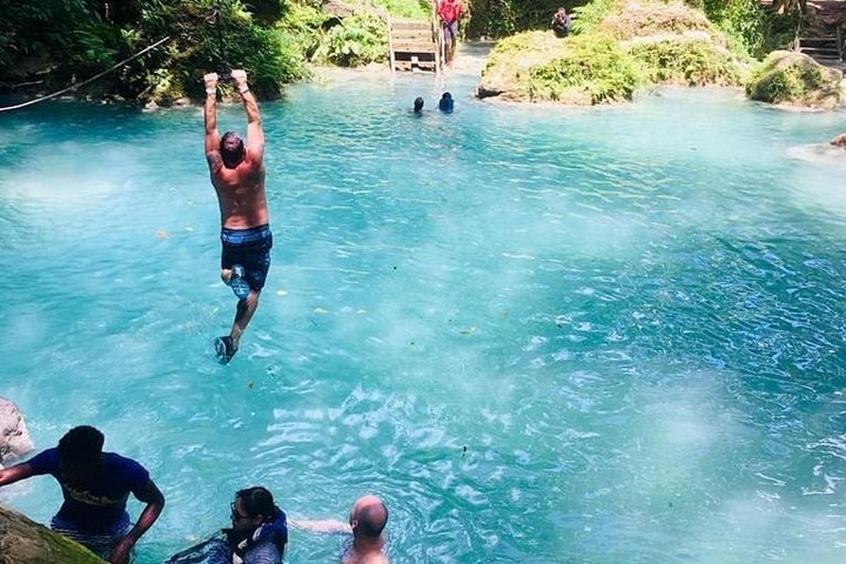 un uomo che salta in una piscina di acqua blu