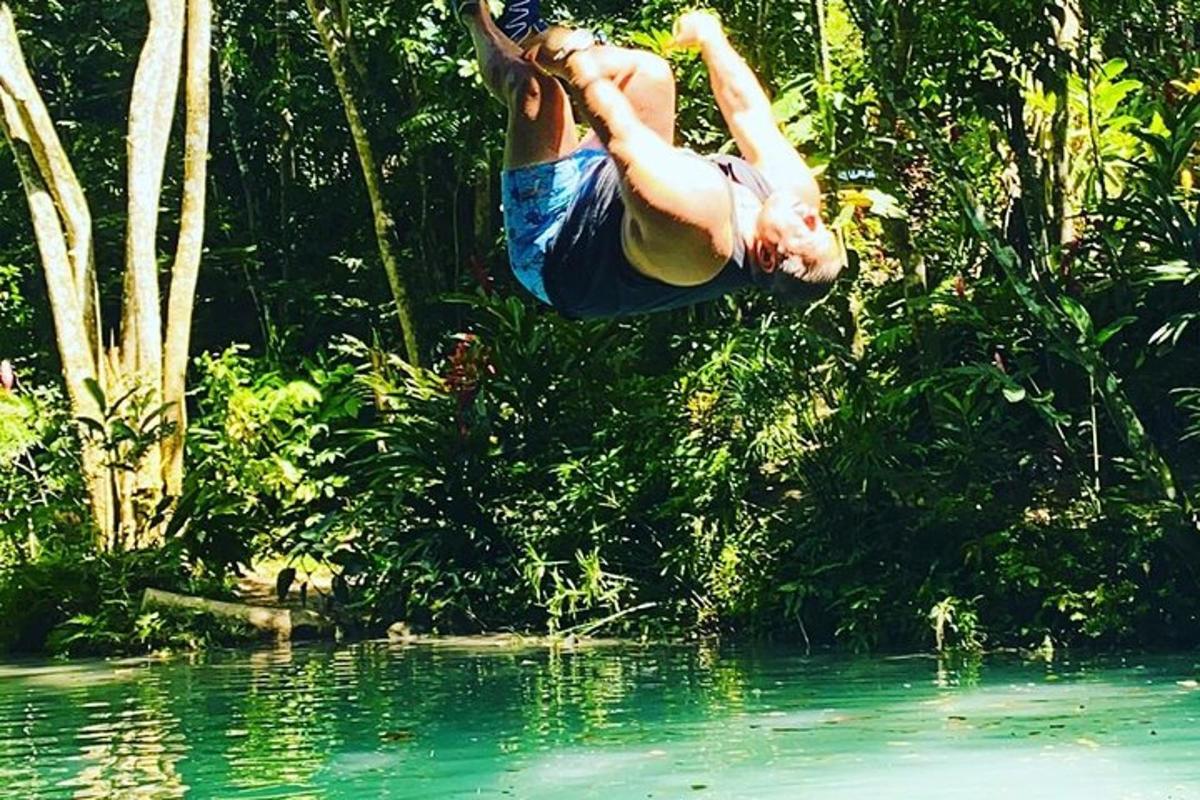 un uomo sta saltando in uno specchio d'acqua