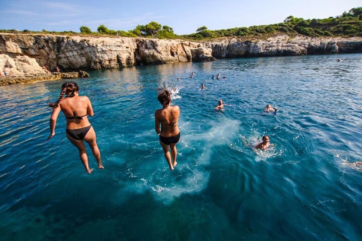 zwei Frauen springen ins Wasser im Ozean
