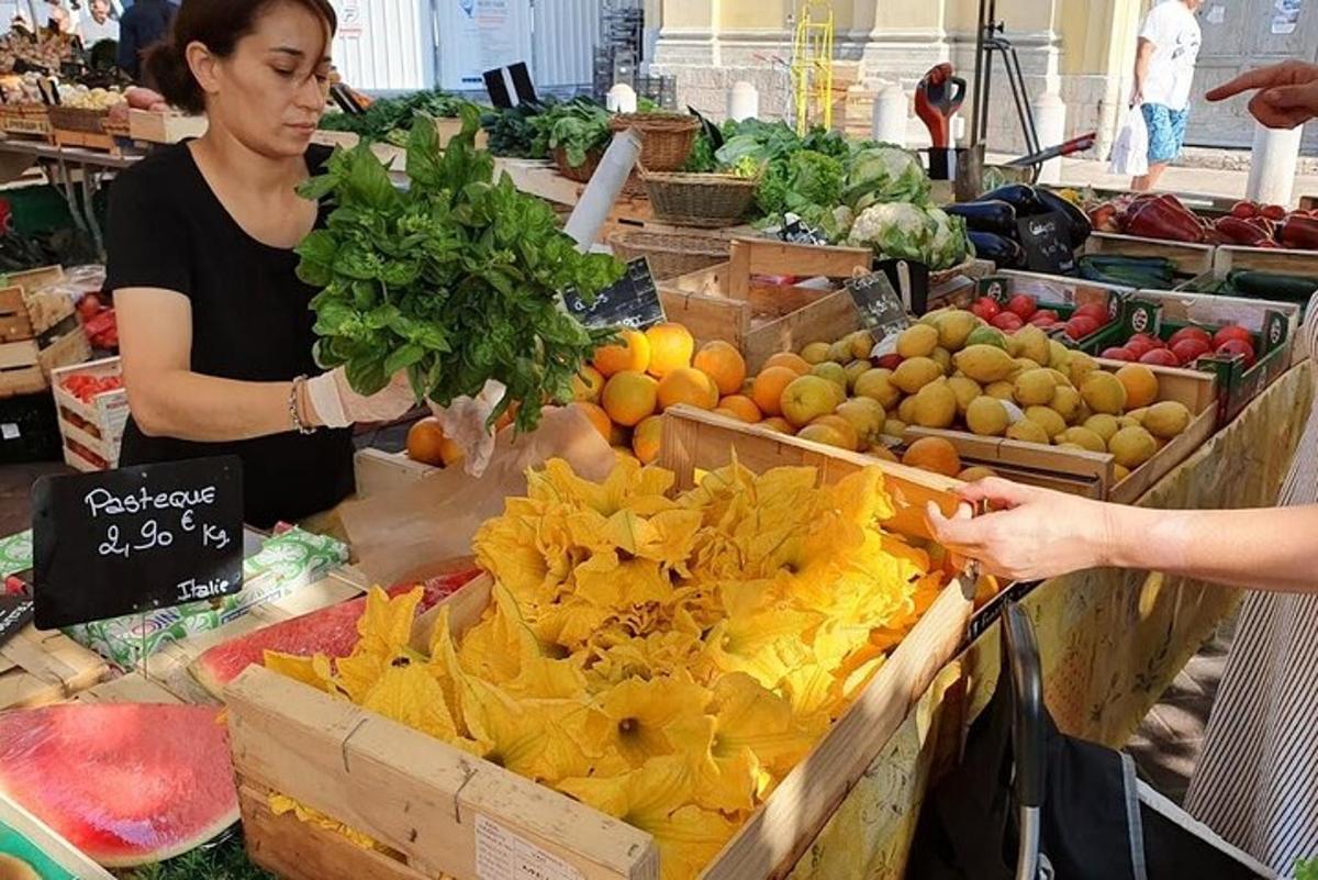 امرأة تقف في السوق مع صندوق من الفواكه والخضروات