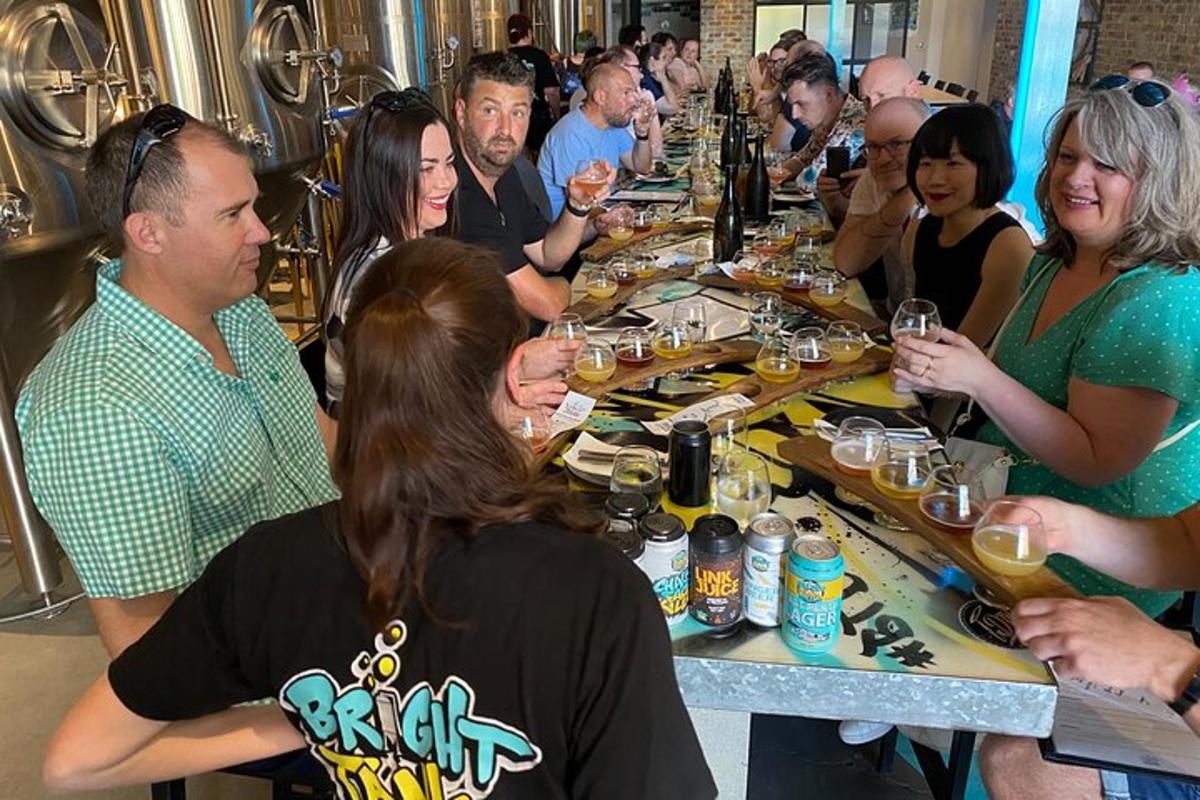 Un grupo de personas sentadas alrededor de una mesa larga con bebidas.