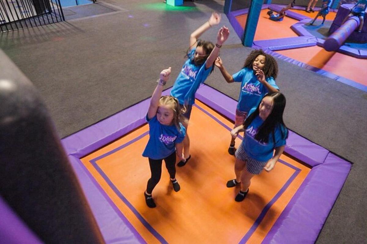 en gruppe barn som danser i en gymsal