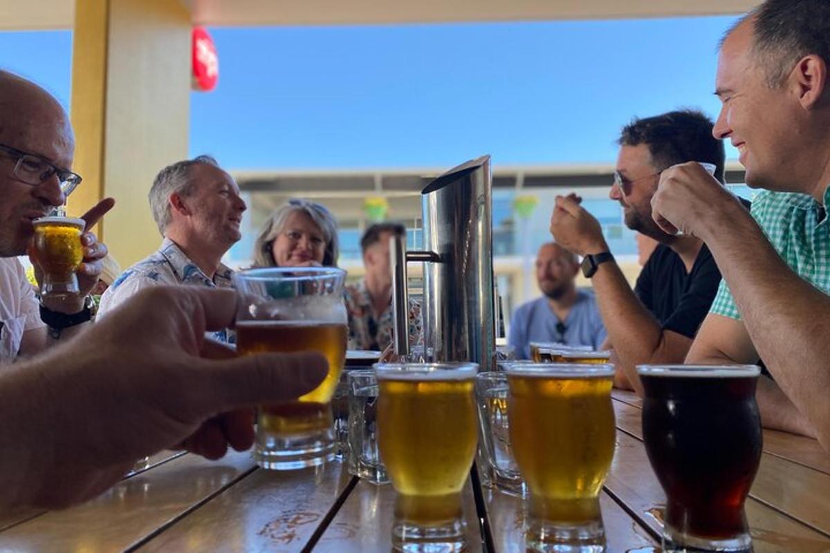 Un grupo de personas sentadas en un bar bebiendo cerveza