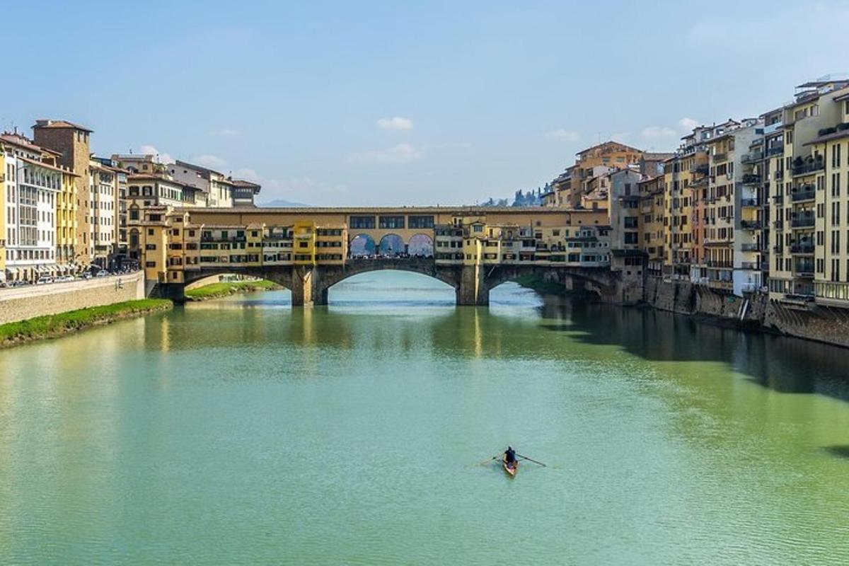 a person in a boat in a river with a bridge