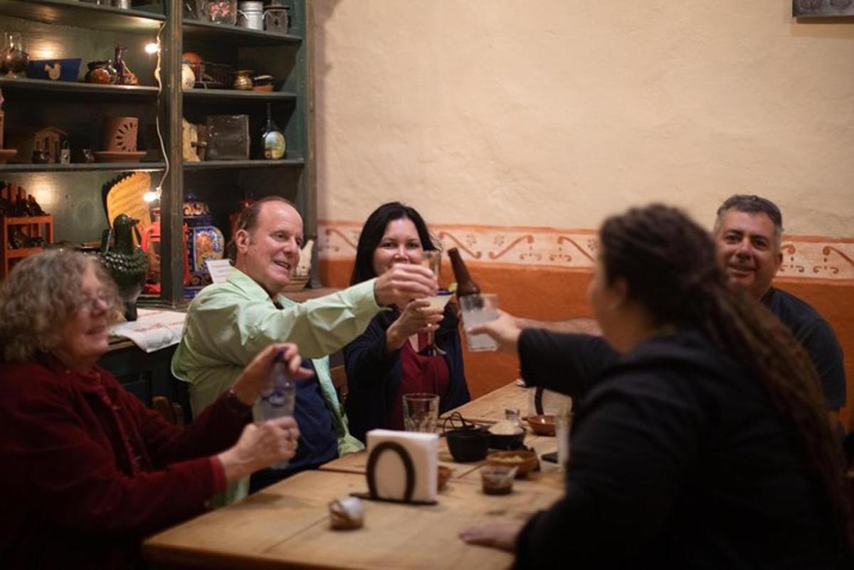 un grup de persones assegudes al voltant d'una taula bevent cervesa