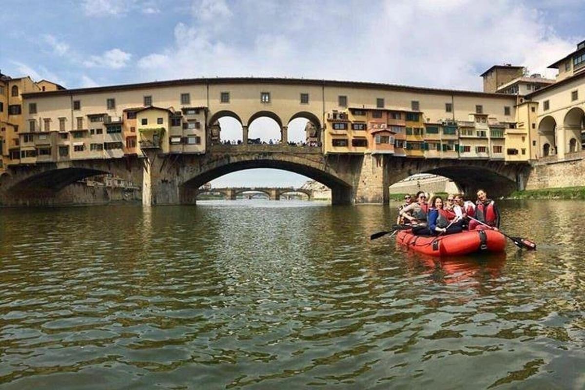 eine Gruppe von Menschen in einem Floß im Wasser in der Nähe einer Brücke
