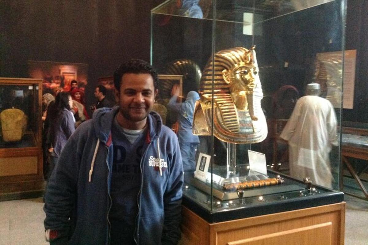 seorang lelaki berdiri di hadapan muzium dengan topeng