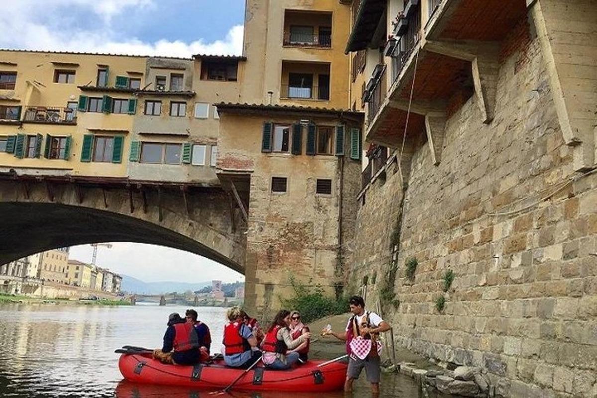 eine Gruppe von Menschen in einem Kanu auf dem Wasser unter einer Brücke