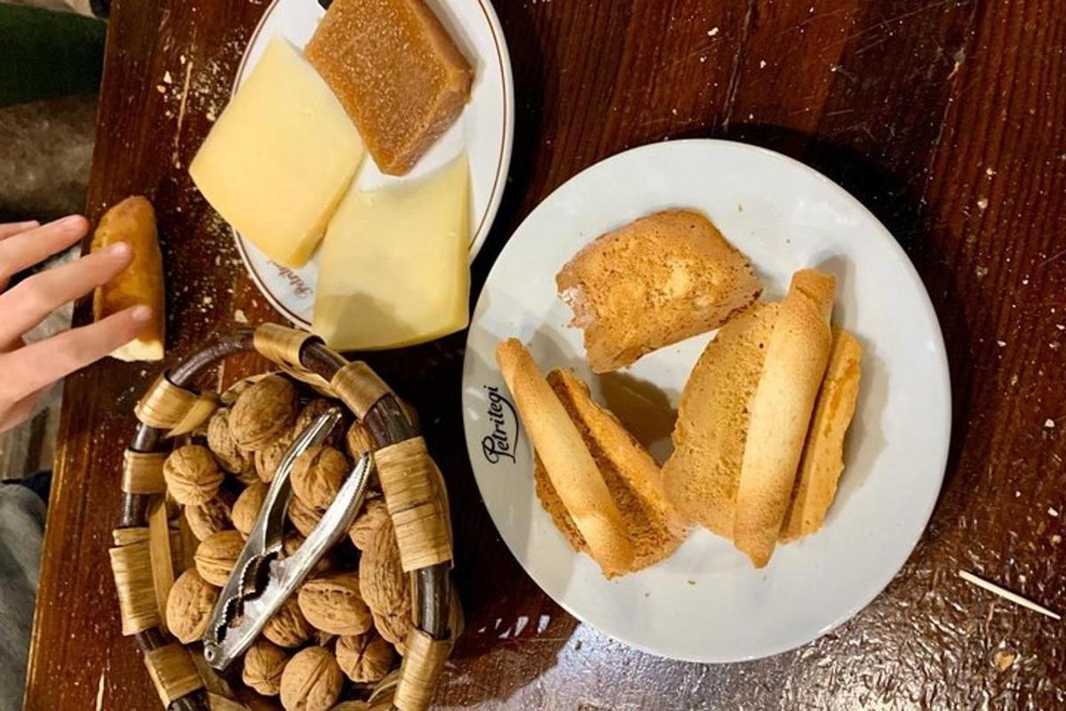 miza z dvema krožnikoma kruha, sira in oreščkov
