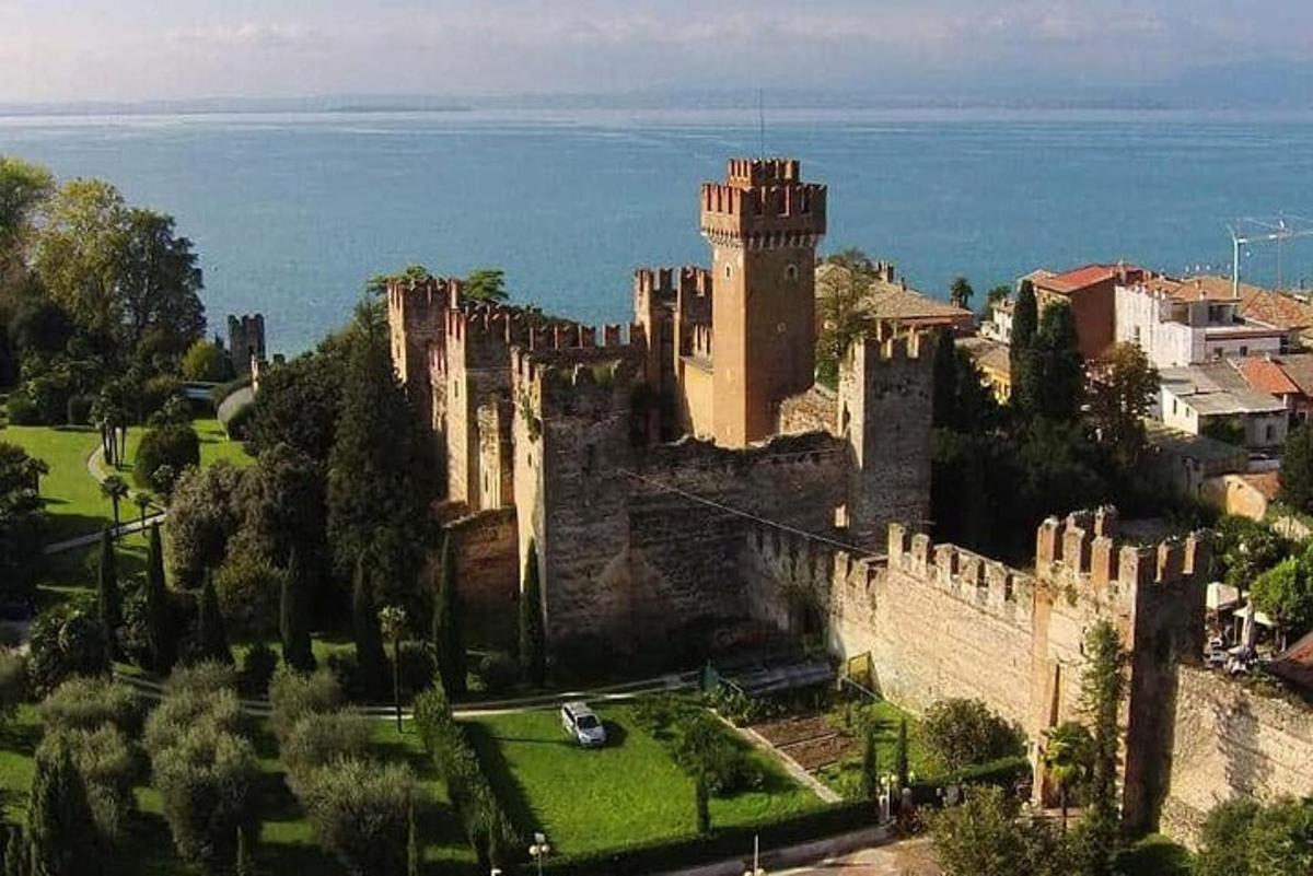 un castello su una collina con l'oceano sullo sfondo