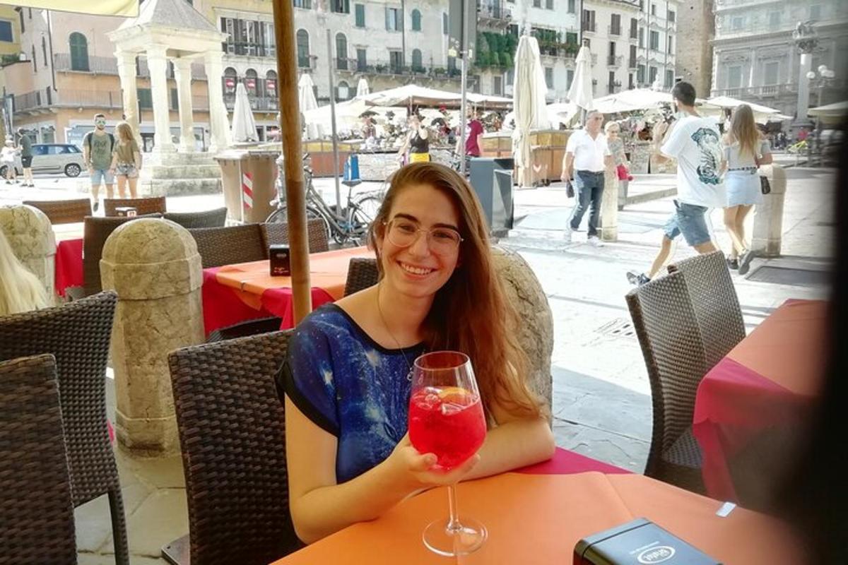 žena sedící u stolu s drinkem
