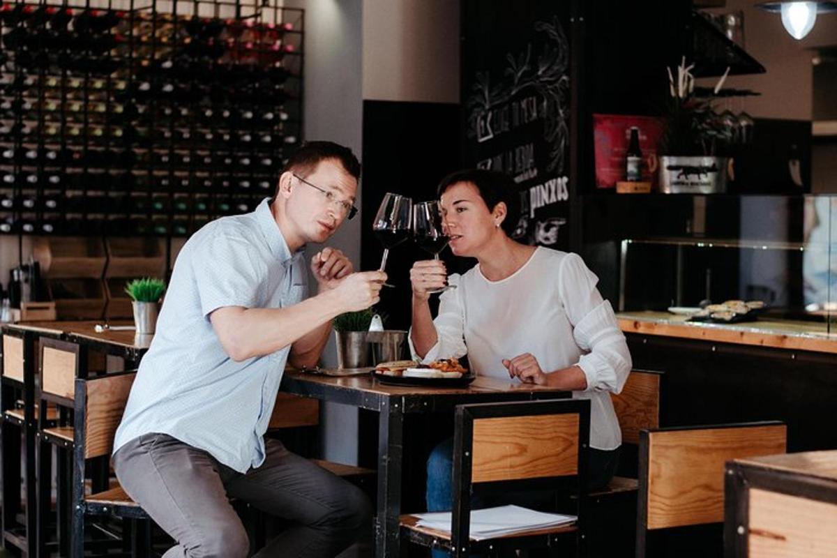 a man and woman sitting at a table drinking wine