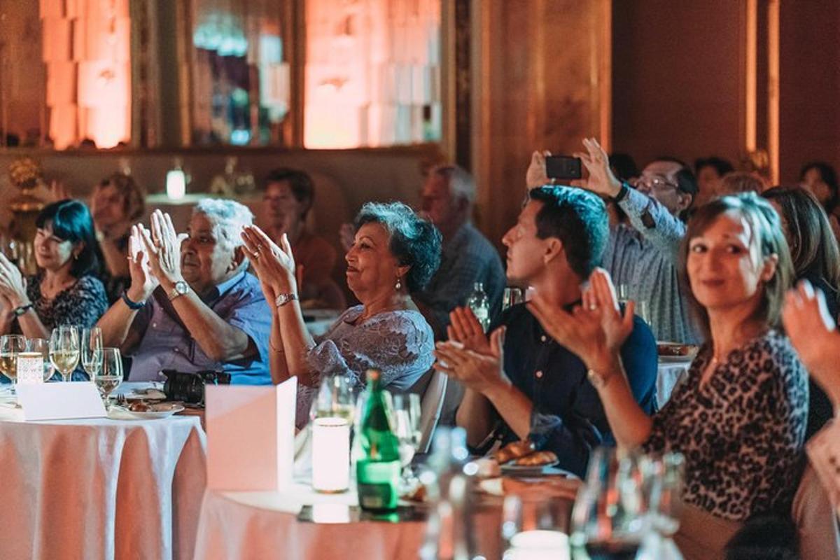 grupp inimesi istub laua taga käed üleval