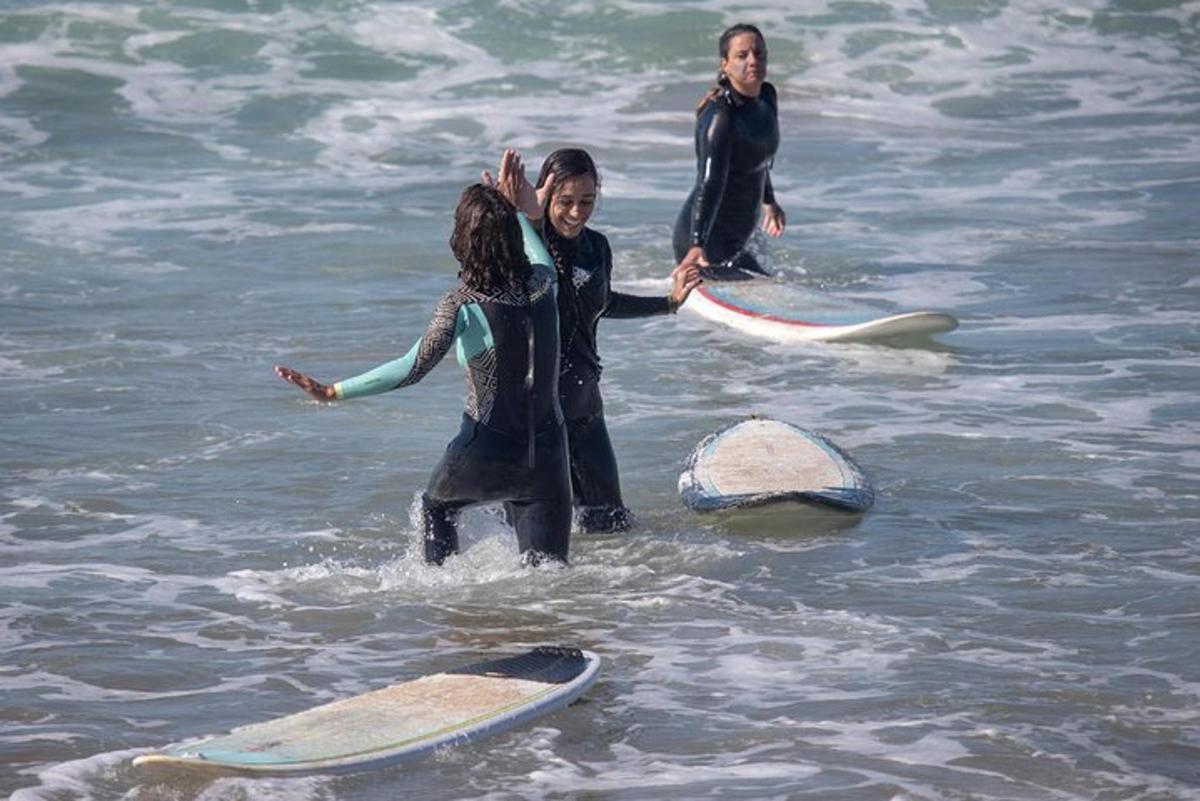 a group of people standing in the water with surfboards