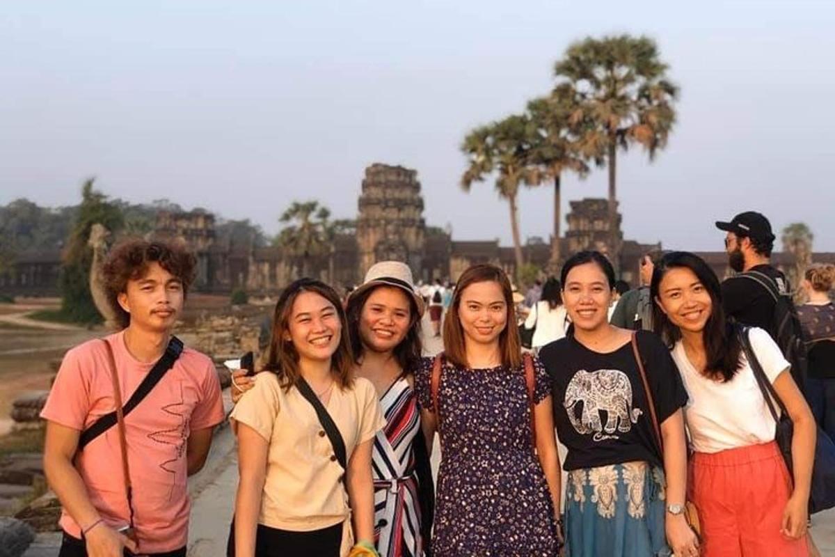 en gruppe mennesker poserer til et billede foran et tempel