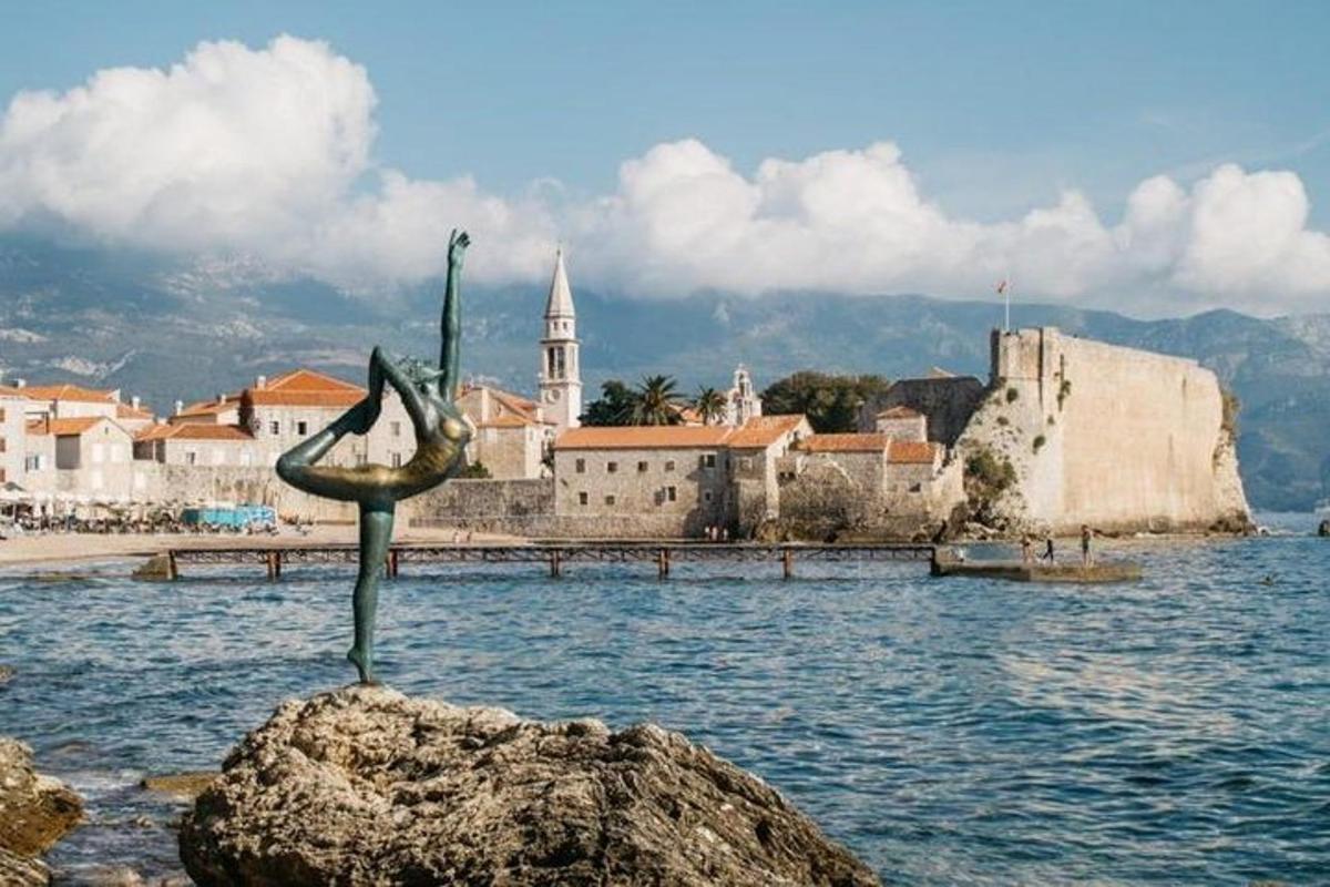 stytta af fugli sem situr á steini í vatninu