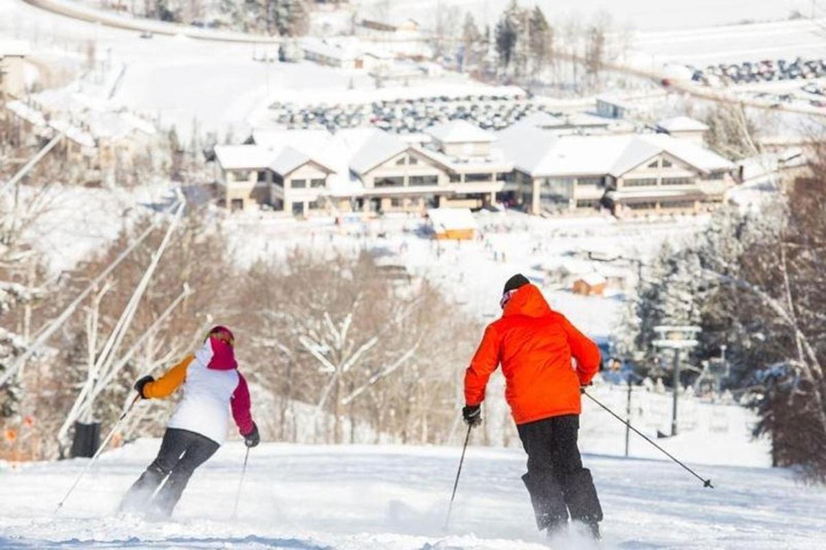 two people are skiing down a snow covered slope