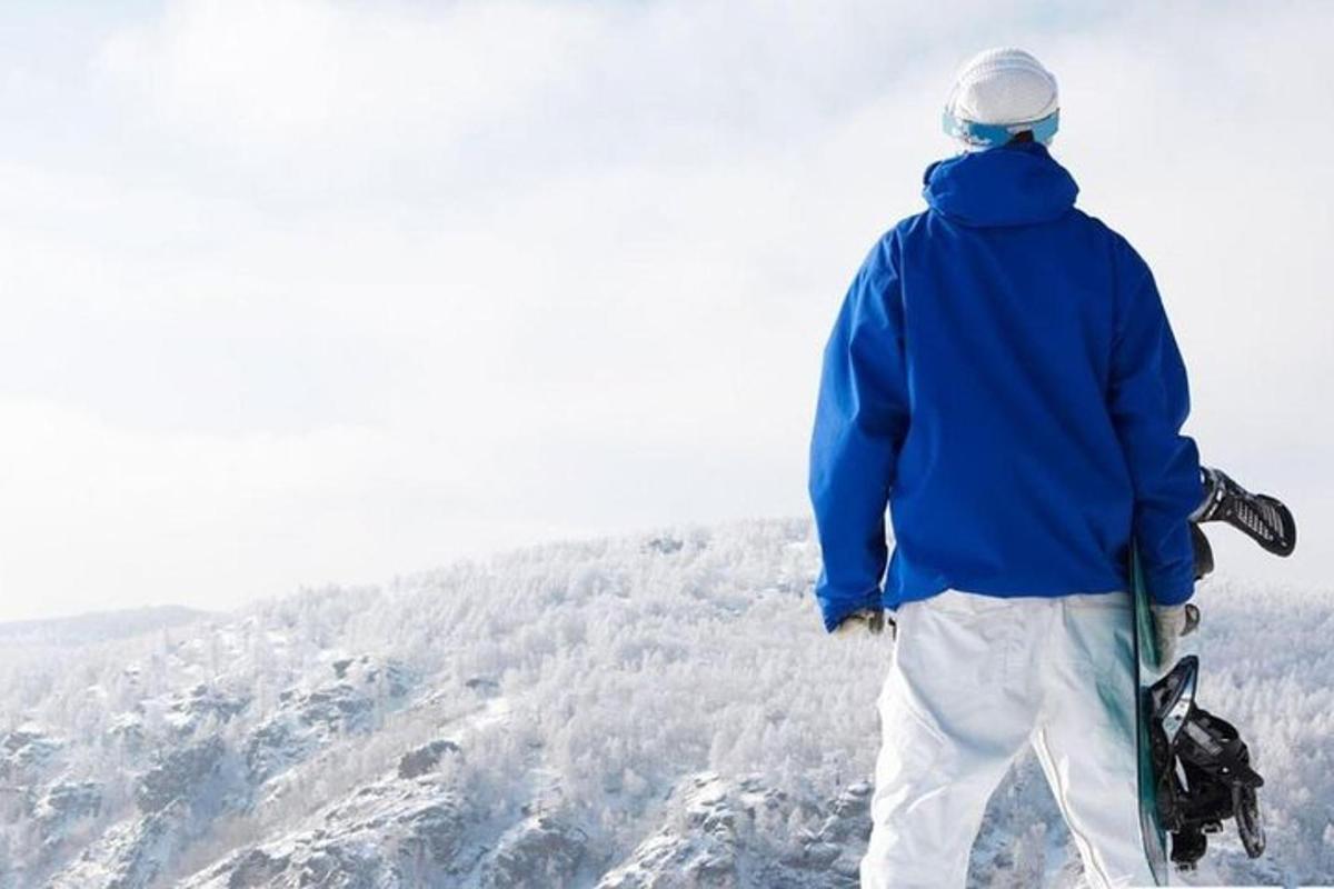 a person holding a snowboard on top of a mountain