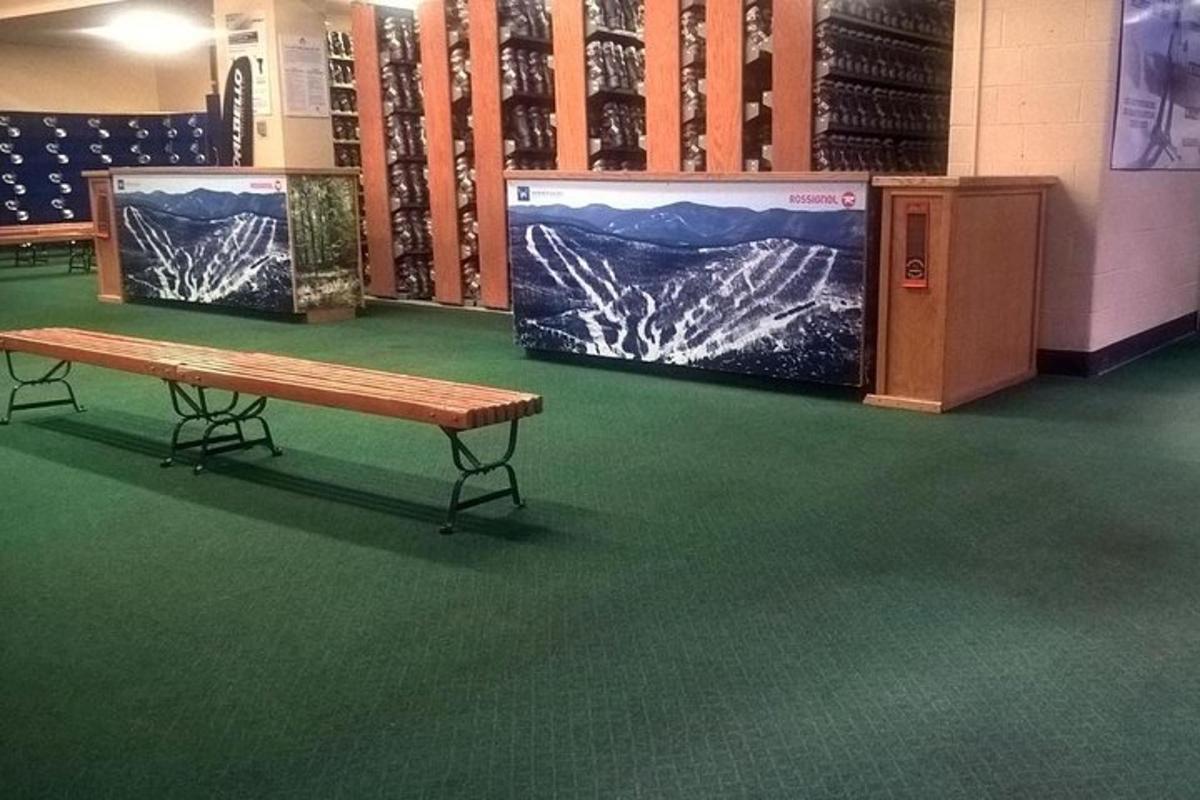 a wooden bench in a room with green carpet