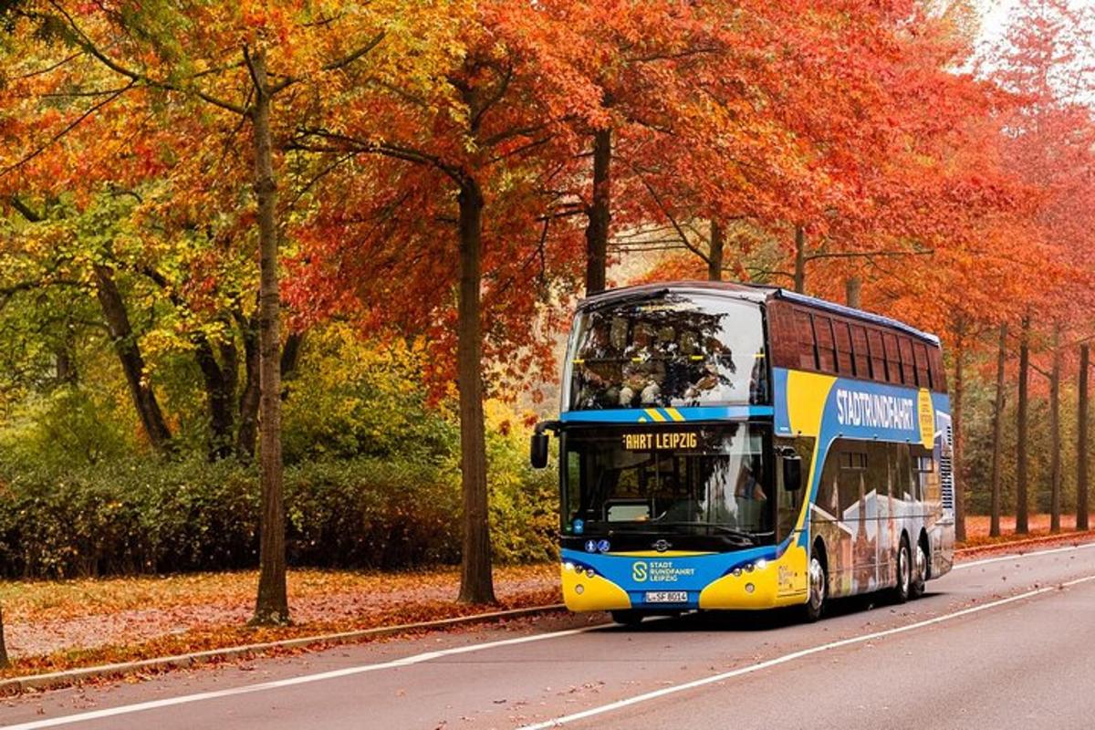 a double decker bus driving down a road with trees