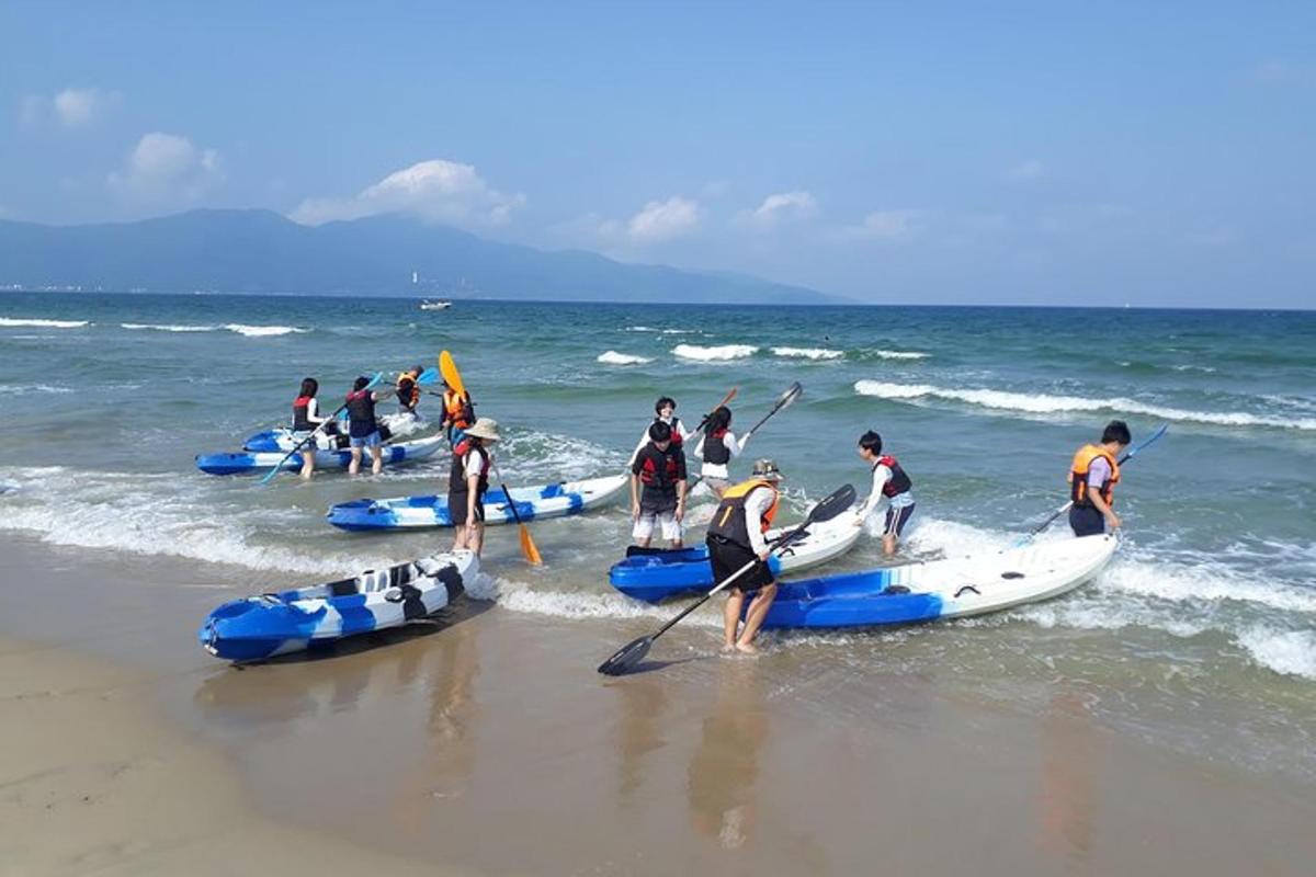 grupa ljudi na plaži s kajacima