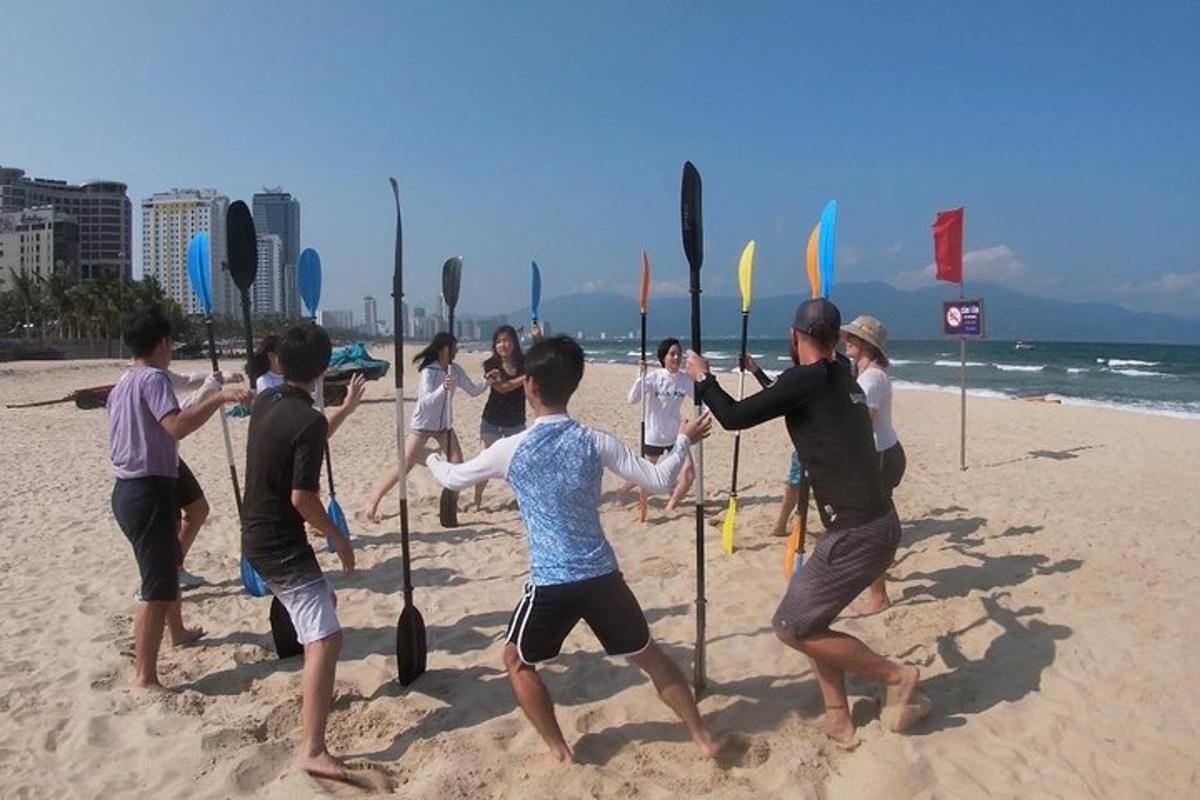 Un grupo de personas de pie en una playa con banderas.