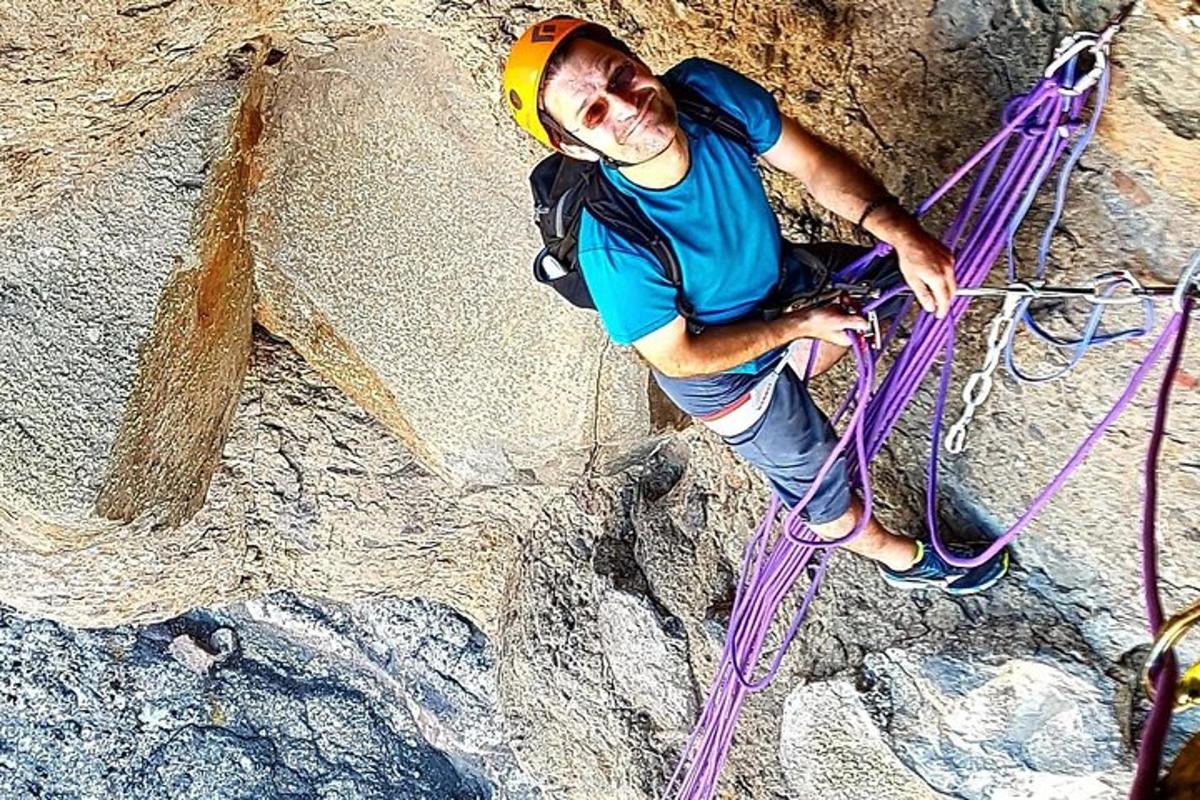 Un hombre está escalando una pared de roca