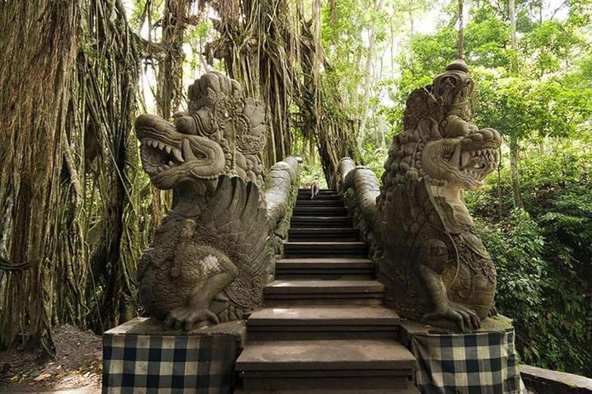 a stairway with two stone statues in a forest