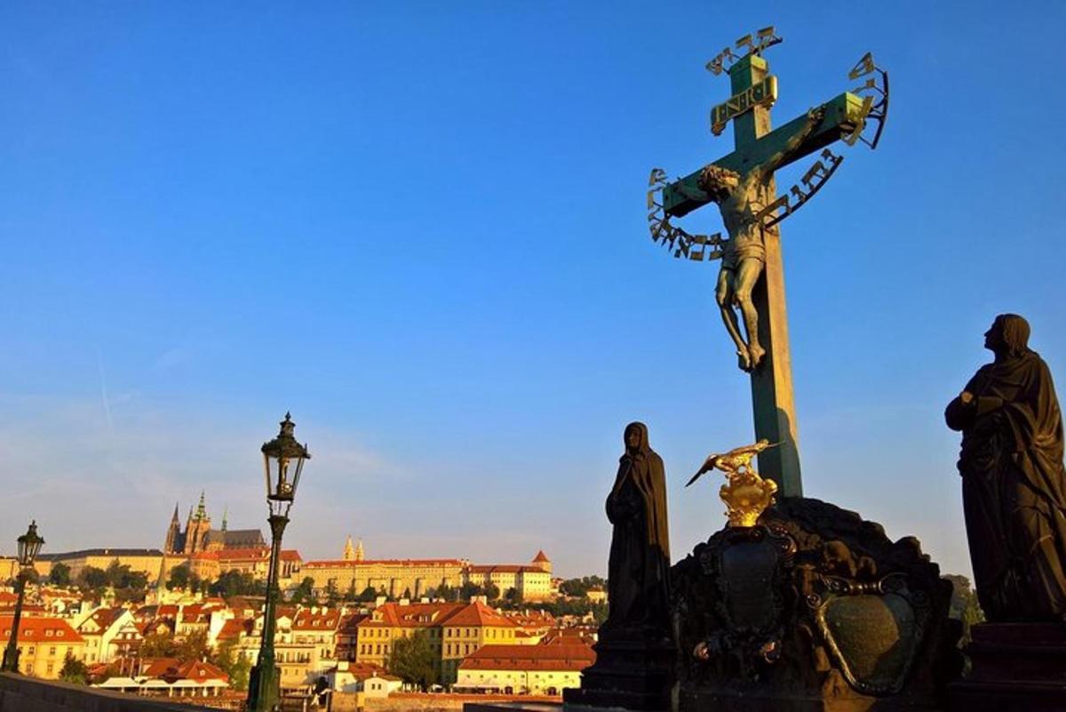 una croce in cima a una statua di fronte a una città
