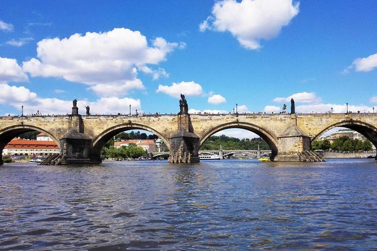 un ponte di pietra sopra un fiume con un ponte sull'acqua
