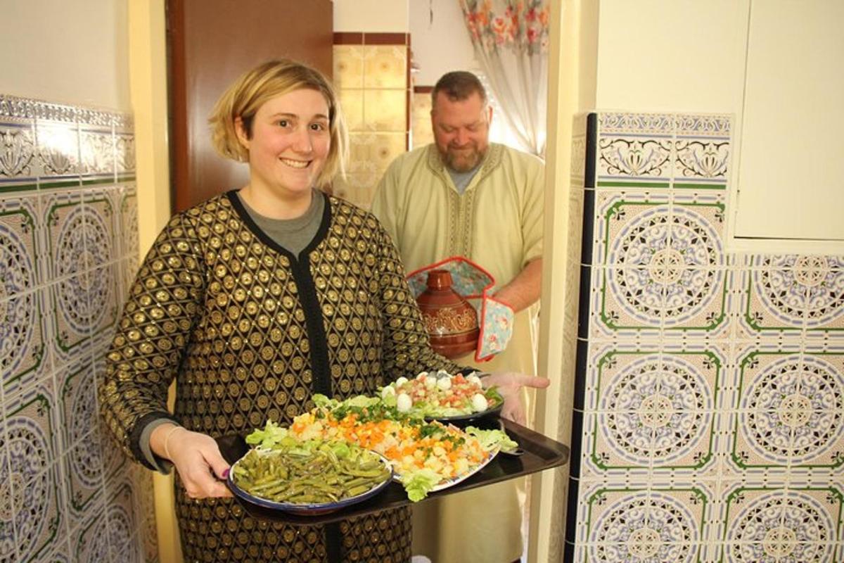 a woman holding a tray of vegetables with a man