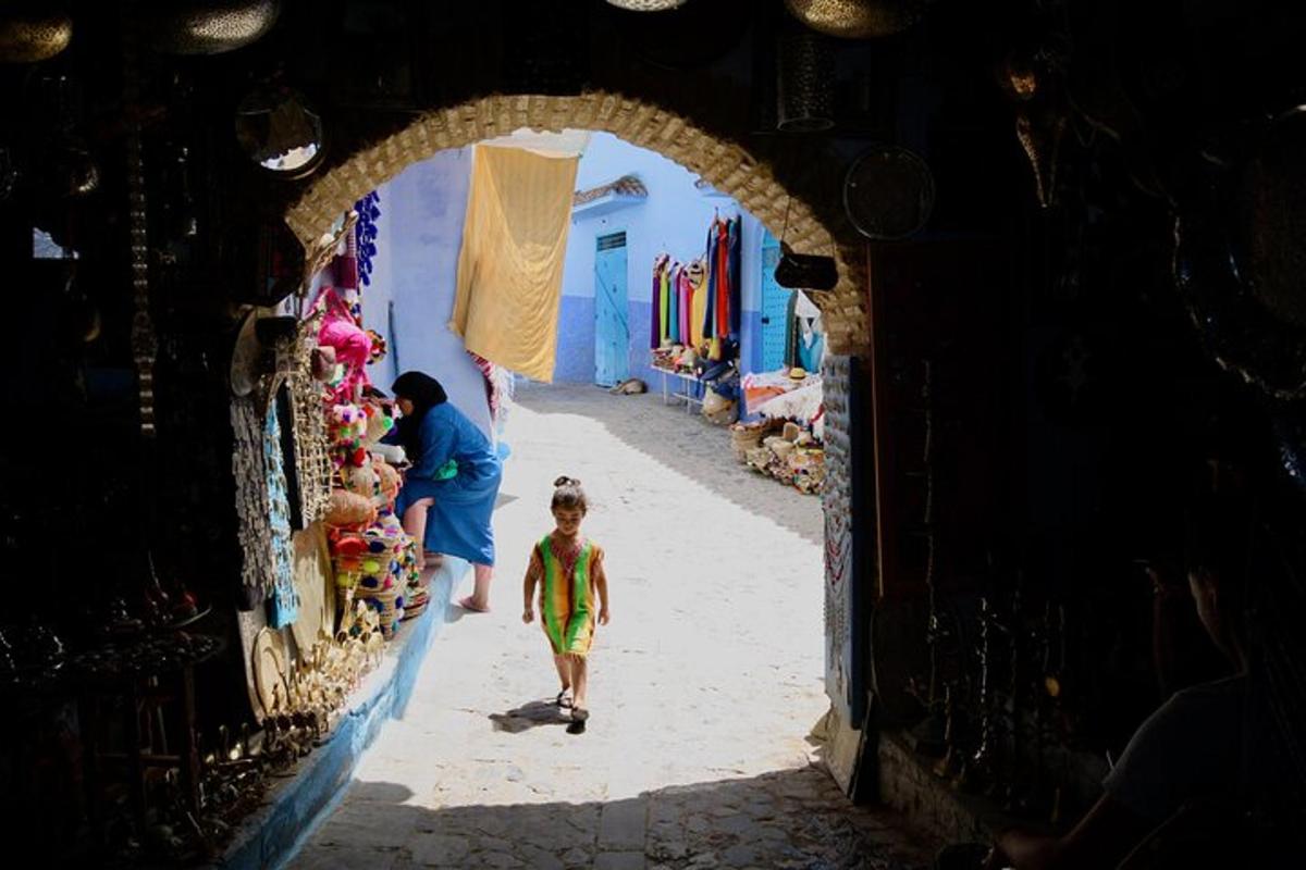 un nen caminant per un arc en un carrer