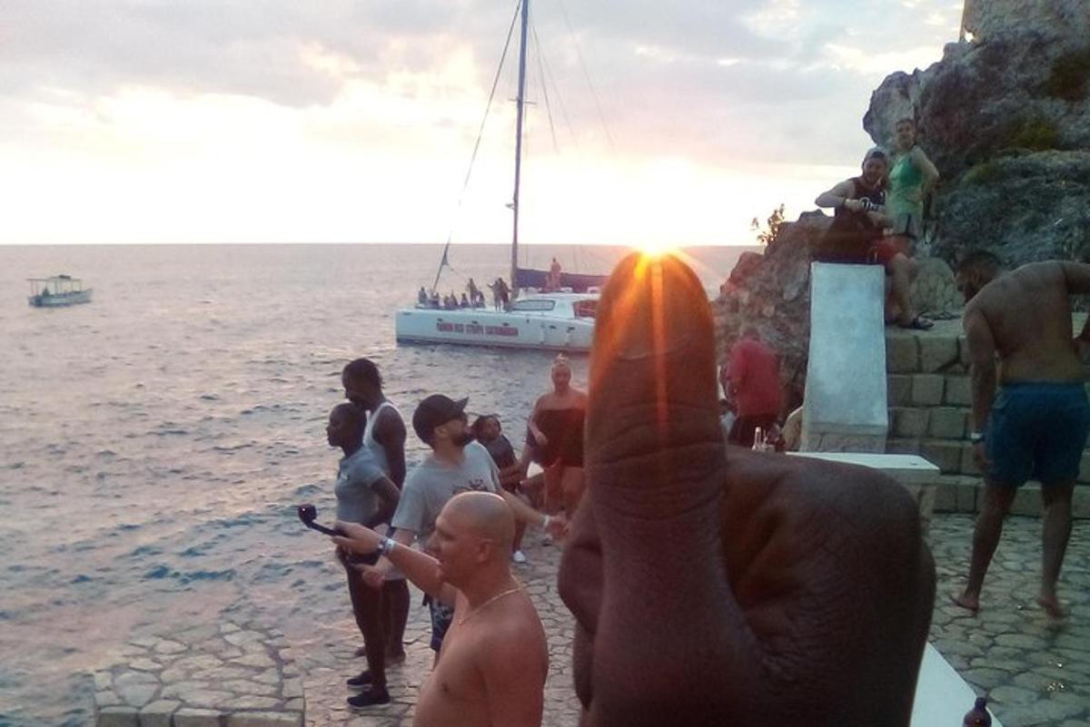 a man taking a picture of a group of people by the water