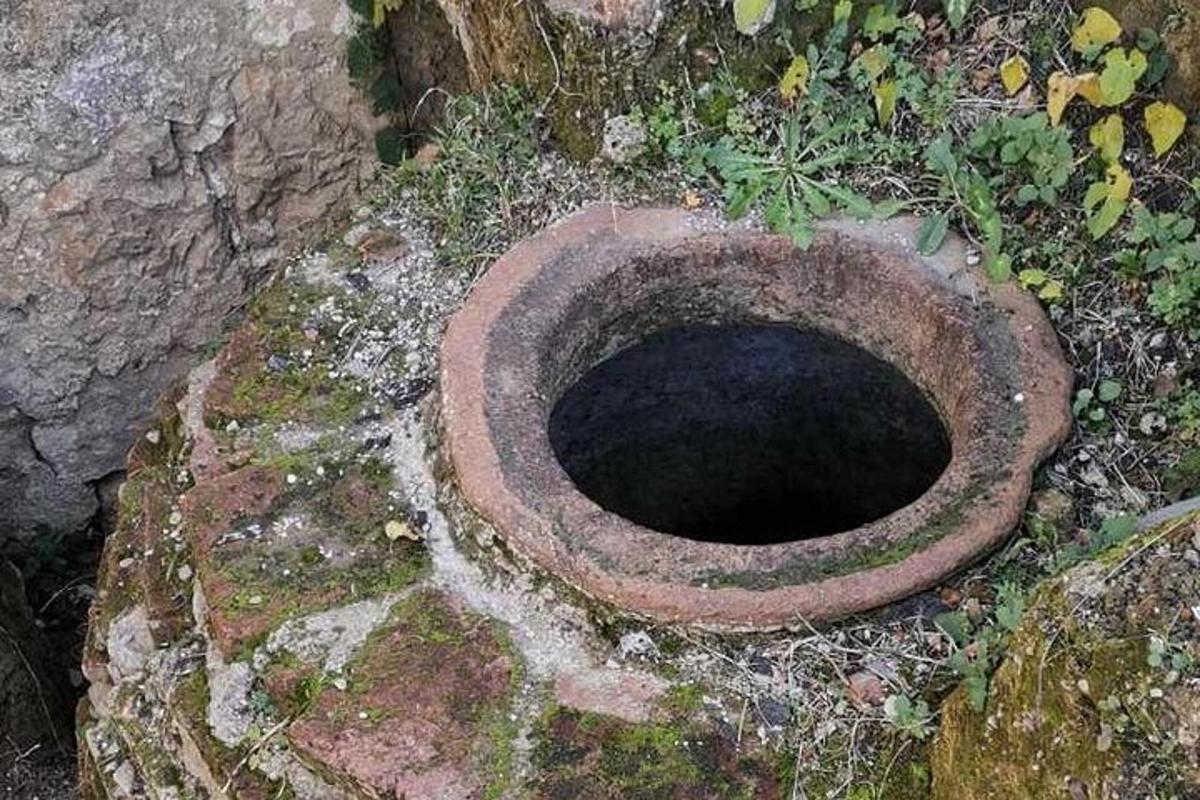 an old toilet sitting on top of a rock