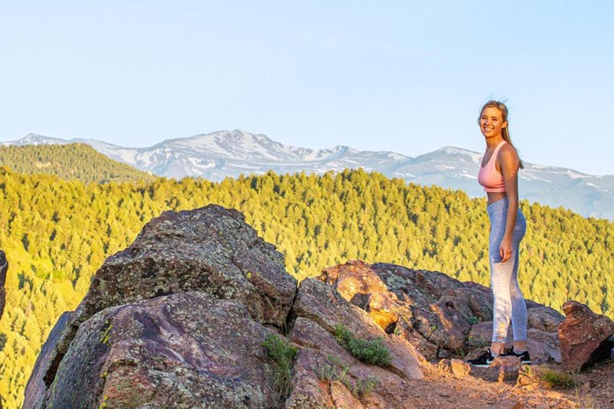 a woman standing on top of a rocky mountain