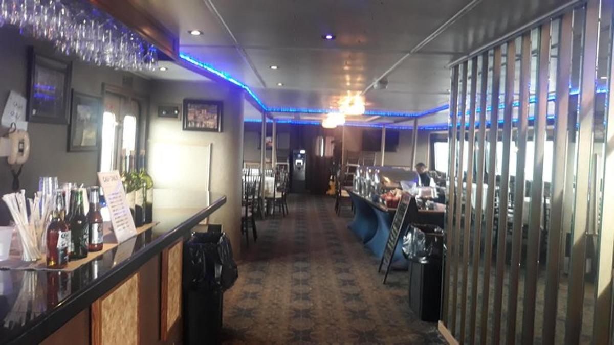 a restaurant with a bar with people sitting at tables