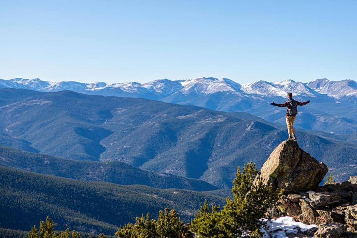 un uomo in piedi su una roccia in cima a una montagna